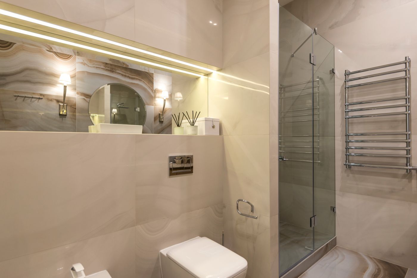 Badkamer met marmerachtige tegels, douche en ledverlichting